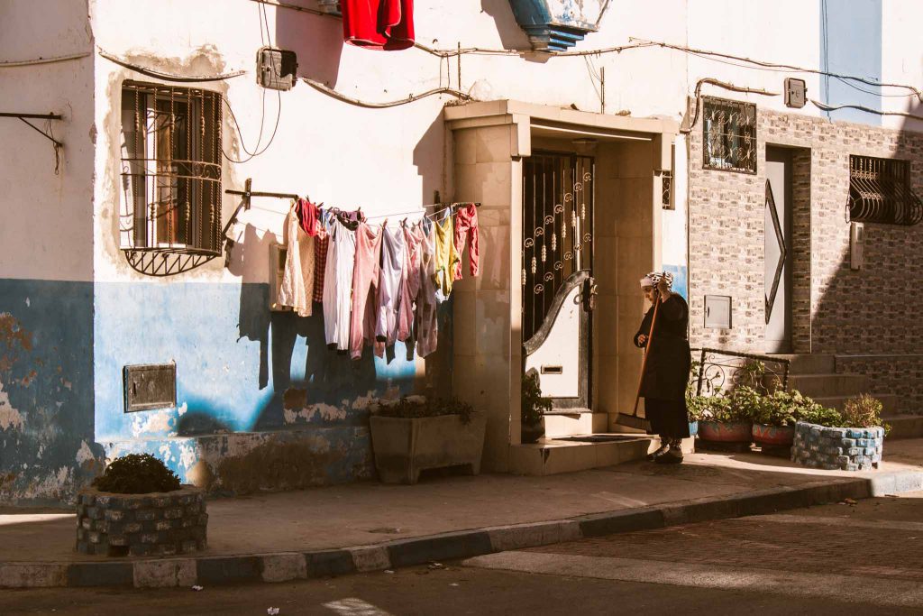 Marokkanerin putzt vor ihrem Haus | Berg- und Talfahrt
